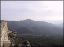 Zttend op het muurtje voor de oude kerk zie je links de zee...